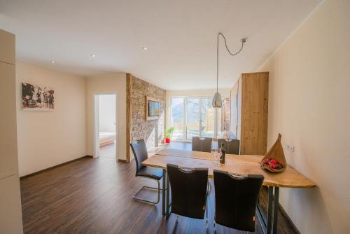a kitchen and dining room with a wooden table and chairs at Bergerhof Alpin Lodge in Neukirchen am Großvenediger