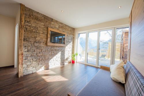 a living room with a couch and a brick wall at Bergerhof Alpin Lodge in Neukirchen am Großvenediger