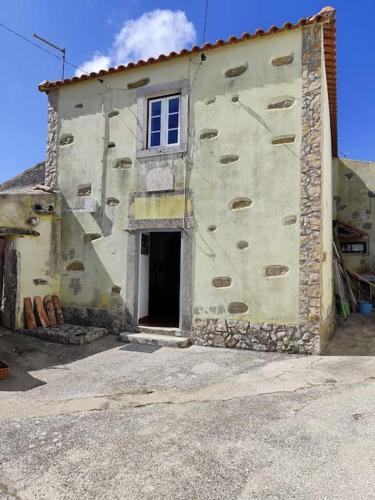 an old stone building with a window and a door at Moradia em Alvarinhos in Alvarinhos