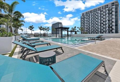 迈阿密Resort Style 1-Bdrm Apt Downtown Doral的一个带桌子和游泳池的庭院