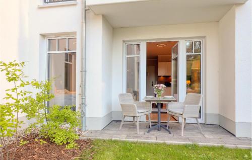 un patio avec des chaises et une table avec des fleurs dessus dans l'établissement Baltischer Hof Apartment 14, à Boltenhagen