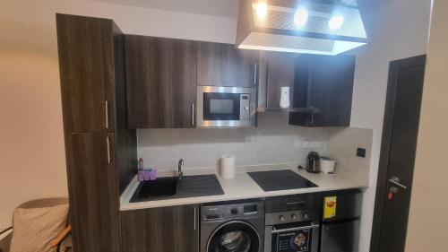 a kitchen with a sink and a washing machine at Embassy gardens Luxury suites CPG in Accra