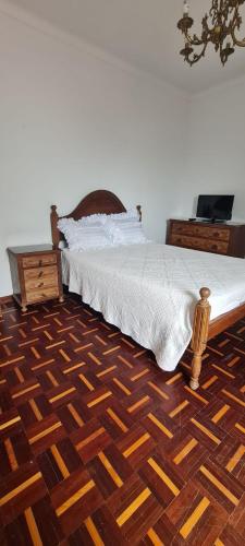 a bedroom with a bed and a wooden floor at House Mariona in Caminha