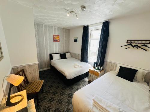 a hotel room with two beds and a window at Tower Central hotel Albert Road in Blackpool