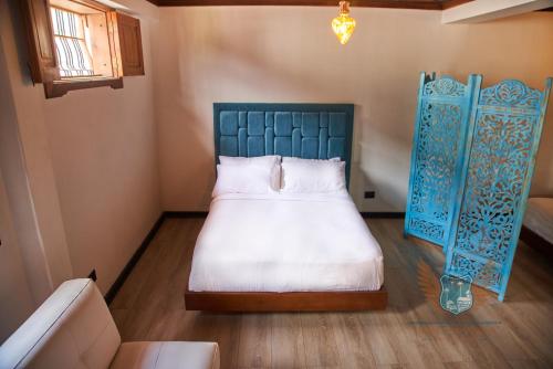 a bedroom with a bed with a blue head board at Hotel San Miguel de Salento in Salento