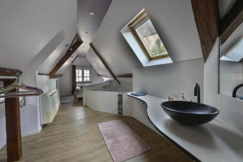 La salle de bains est pourvue d'un lavabo à bol noir et d'une baignoire. dans l'établissement i-love-colmar - Le 8 de Coeur - Garage gratuit, à Colmar