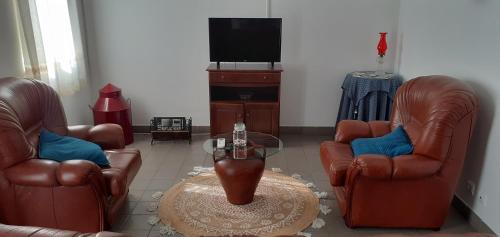 a living room with two leather chairs and a coffee table at Recanto da Luz in Luz