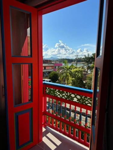 a red door leading to a balcony with a view at Apto en la calle de las sombrillas para estrenar, la mejor ubicacion en guatape garantizada in Guatapé