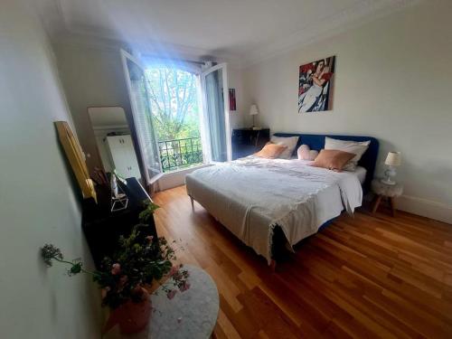 une chambre avec un grand lit et une grande fenêtre dans l'établissement Apparemment zone olympique, à Paris