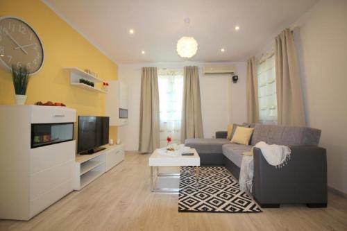 a living room with a couch and a tv at Bungalow Lavanda mit Pool und Garten in Porec in Poreč