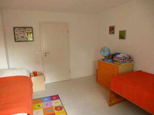 una camera con due letti, un comò e una porta di Ferienwohnung in Vorland mit Grill und Garten a Vorland
