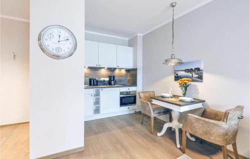 a kitchen and dining room with a table and a clock at Baltischer Hof Apartment 43 in Boltenhagen