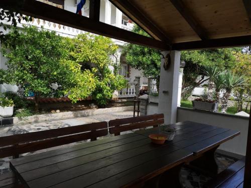 a wooden table and bench on a porch at Apartment in Lopar with sea view, terrace, air conditioning, washing machine 593-3 in Lopar