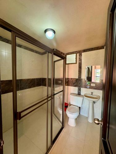 a bathroom with a toilet and a sink at Hotel Portal Dorado in Marinilla