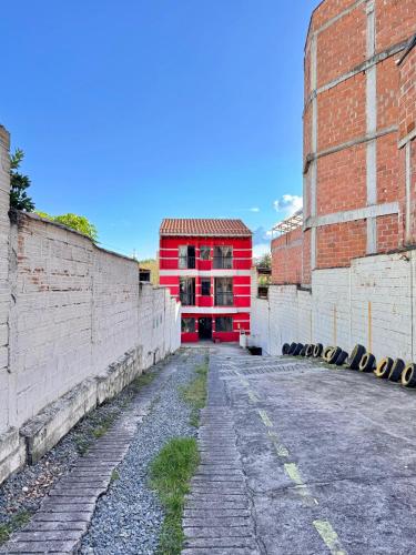 a red building in the middle of a street at Hotel Portal Dorado in Marinilla