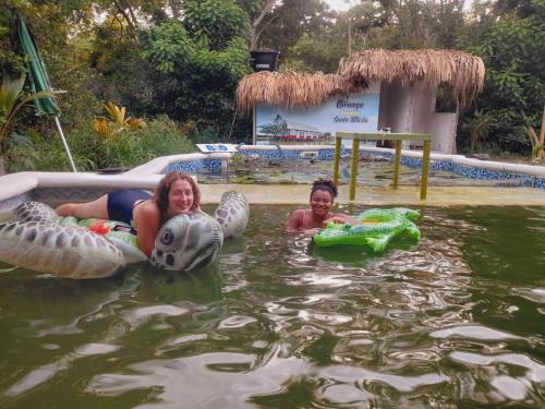 two girls are swimming in a pool of water at Bio Coliving Tayrona in Santa Marta