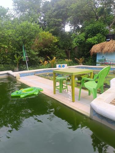 a table and chairs next to a pool of water at Bio Coliving Tayrona in Santa Marta