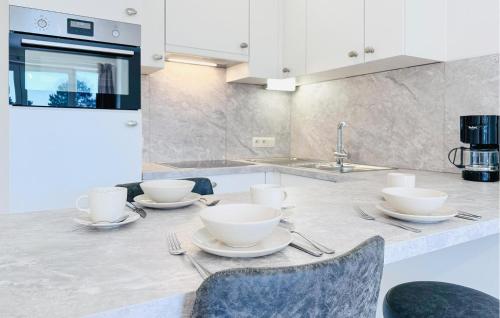 a kitchen with a table with plates and utensils at Awesome Apartment In Bredene With Wifi in Bredene