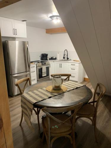 a kitchen with a table with chairs and a refrigerator at Drift in Goderich