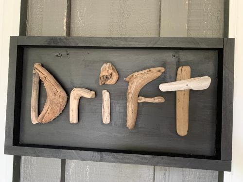 a wooden sign that says home with someones name at Drift in Goderich