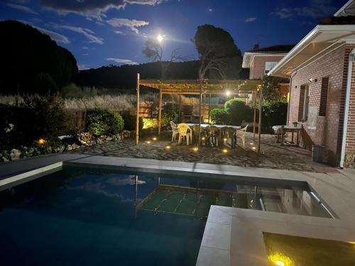 a backyard with a swimming pool at night at Gorriones in Pelayos de la Presa