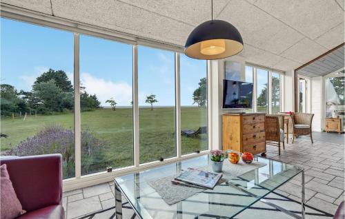 a living room with a glass table and large windows at Holiday Home Flejmose Sydals Xii in Kegnæshøj