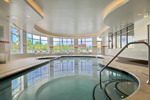 a large swimming pool in a building with a large ceiling at Hilton Garden Inn Denver/Cherry Creek in Denver