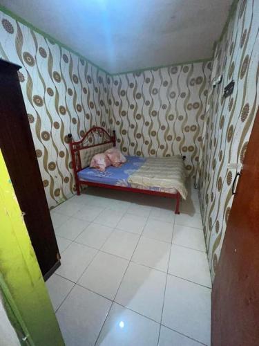 a small childs bed in a corner of a room at Hong Kost Homestay Putra Csb Mall in Cirebon