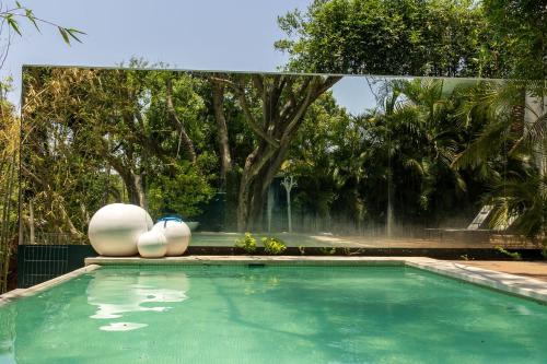 a swimming pool with two white eggs and a fountain at New Santa Fe Home Private Relaxation Realm in Xochitepec