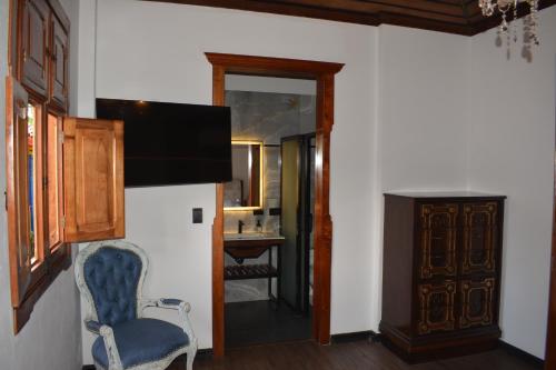 a living room with a chair and a mirror at Hotel San Miguel de Salento in Salento
