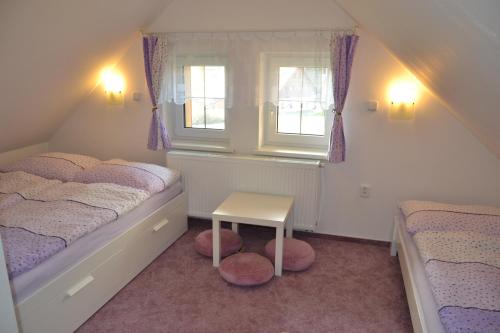 a small bedroom with two beds and a table at Apartmány Ski Lift in Rokytnice nad Jizerou