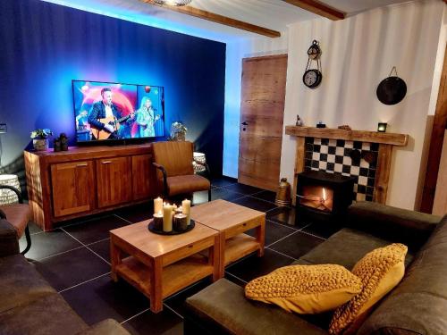 un salon avec une télévision et une cheminée dans l'établissement Ferienwohnung Aineck in Sankt Michael im Lungau, à Sankt Michael im Lungau