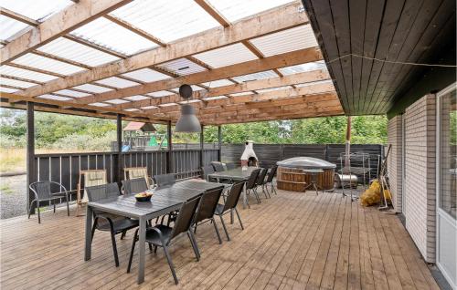 HemmetにあるHoliday Home Hemmet With Hot Tub Viのパティオ(テーブル、木製デッキの椅子付)