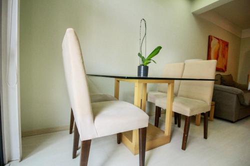 a dining room table with white chairs and a dining room at Apartamento Duplex Place Vendome! Moema, 58m2, Amplo, Conforto, Luxo! Servicos, Estacionamento, Internet, Metro! in Sao Paulo