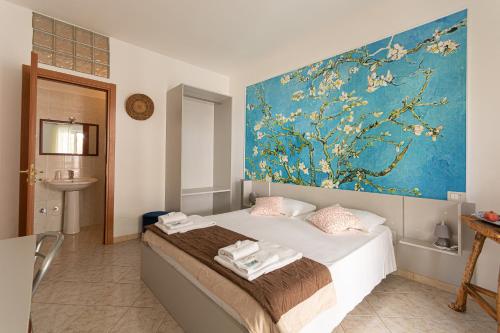 a bedroom with a bed with a painting on the wall at vila SEJUDA Alberghetto in Peschici