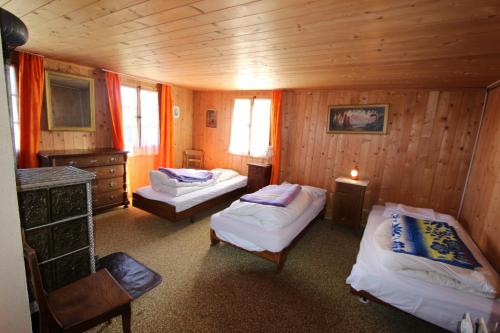um quarto com 2 camas num chalé de madeira em Plans em La Lécherette