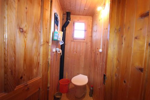 a bathroom with a toilet in a wooden wall at Plans in La Lécherette