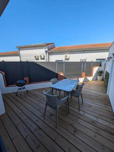 un patio avec une table et des chaises sur une terrasse dans l'établissement Magnifique appartement Mimizan, à Mimizan