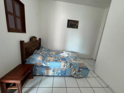 a bedroom with a bed and a wooden table at Pousada Vilasboas in Parintins