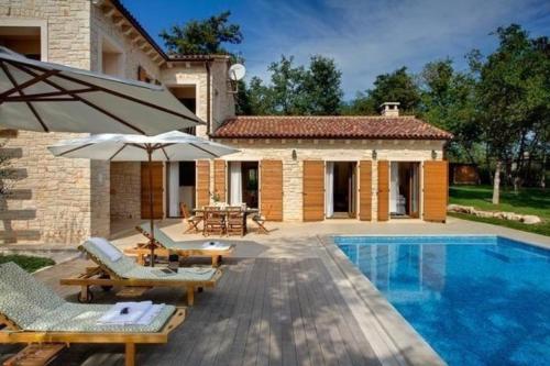 una villa con piscina y una casa en Ferienhaus in Karigador mit Terrasse, Whirlpool und Garten, en Karigador