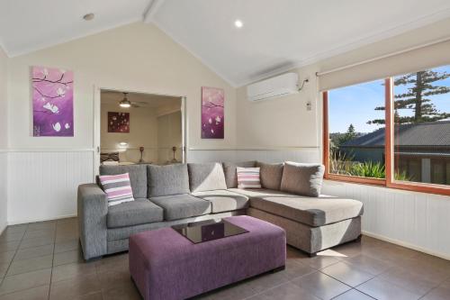 a living room with a couch and a table at Kiama Harbour Cabins in Kiama