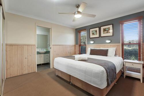 a bedroom with a large bed and a bathroom at Kiama Harbour Cabins in Kiama