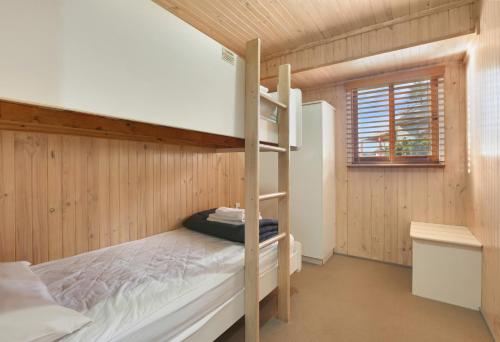 a bedroom with a bunk bed with a ladder at Kiama Harbour Cabins in Kiama