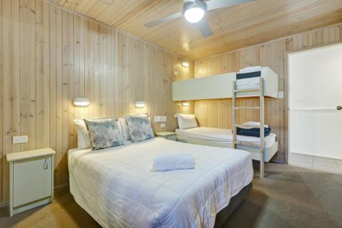 a bedroom with a bed and a bunk bed at Kiama Harbour Cabins in Kiama
