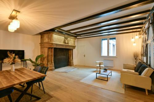 a living room with a fireplace and a table at La Dame Blanche - Appartement hypercentre historique - Parking privé in Bourges