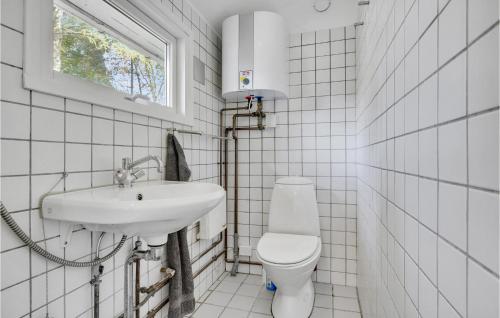 a white bathroom with a sink and a toilet at Holiday Home Hindebregnen in Kirke-Hyllinge