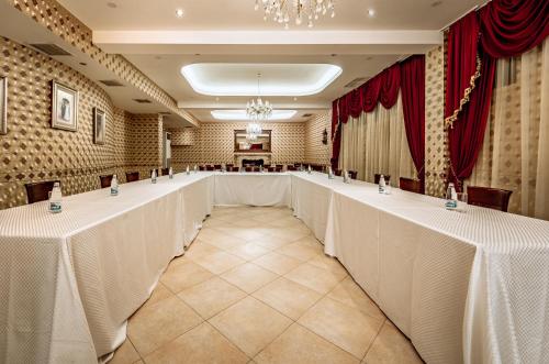 a row of tables in a room with red curtains at Hotel Winpalace in Arbanasi