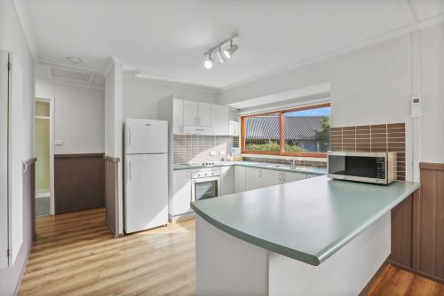 a kitchen with a white refrigerator and a counter top at Kiama Harbour Cabins in Kiama
