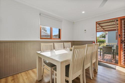 a dining room with a wooden table and chairs at Kiama Harbour Cabins in Kiama