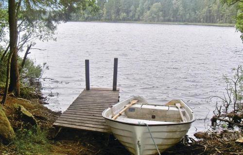 a boat parked next to a dock on a lake at Awesome Home In Ryd With Kitchen in Ryd